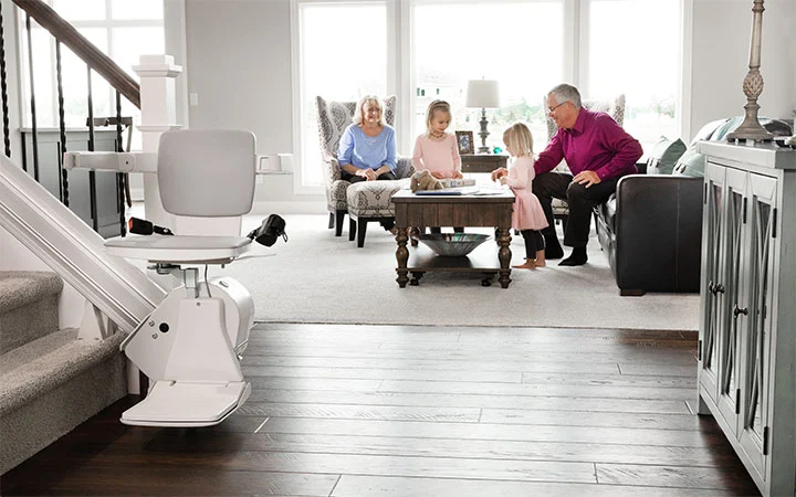 grandparents watching two young kids play in the living room 