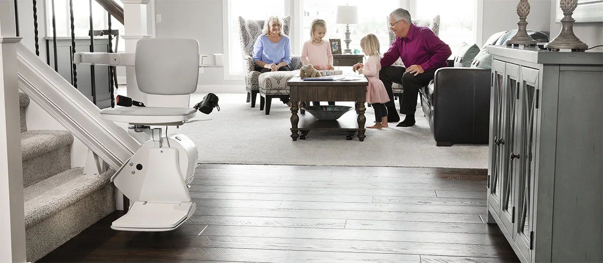 grandparents watching two young kids play in the living room 