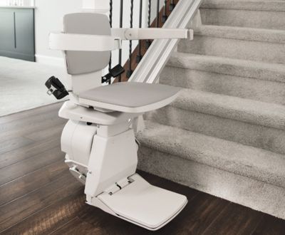 Image of a Bruno stairlift parked at the bottom of a staircase showing how easy stairlifts are to use