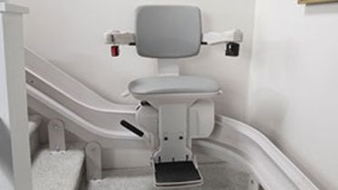Bruno Elite Curved indoor stairlifts midpark option on a gray carpet staircase