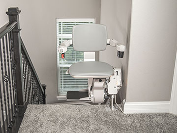 Bruno Elite Curved indoor stairlift parked at the top of the steps with the seat swiveled