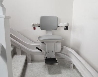 Bruno Elite Curved indoor stairlift near a staircase landing