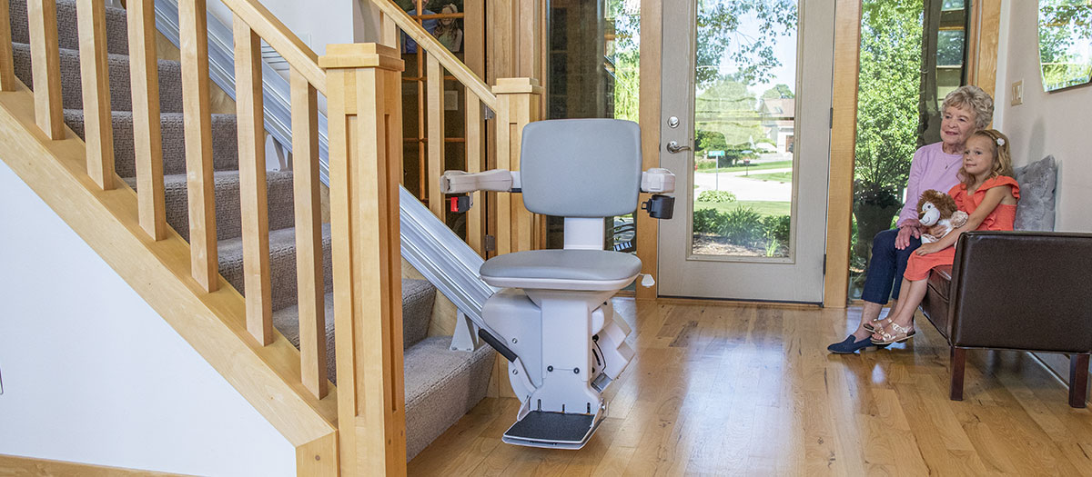 Bruno stairlifts helping a gandmother and granddaughter enjoy time sitting in a foyer