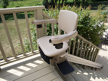 Bruno Elite straight outdoor stairlift parked and swiveled at the top of a wooden stairway